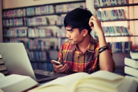 The young man is studying for knowledge in the library Stock Photos