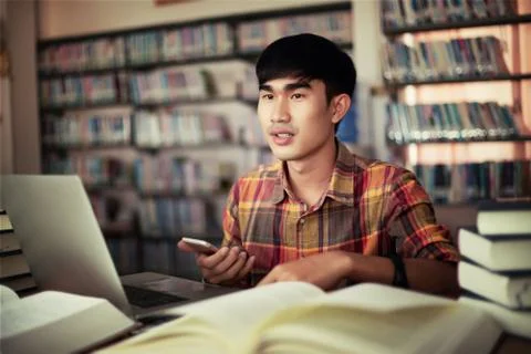 The young man is studying for knowledge in the library Stock Photos