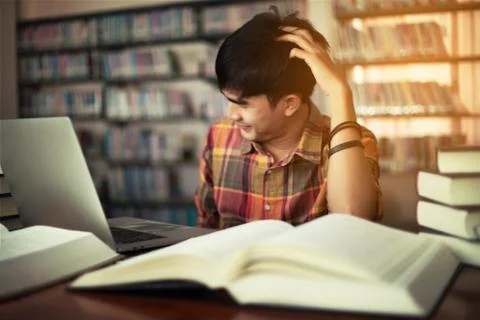 The young man is studying for knowledge in the library Stock Photos