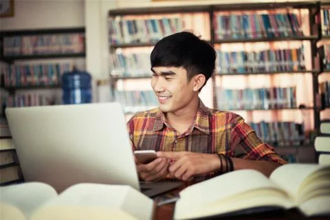 The young man is studying for knowledge in the library Stock Photos