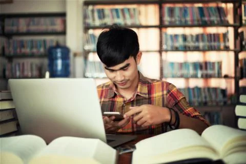 The young man is studying for knowledge in the library Stock Photos
