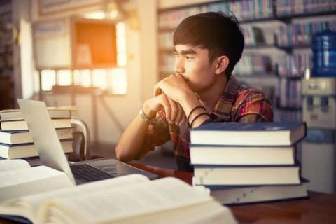 The young man is studying for knowledge in the library Stock Photos
