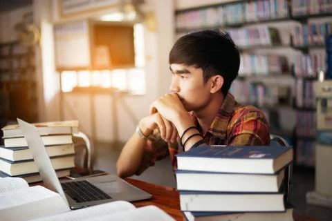 The young man is studying for knowledge in the library Stock Photos