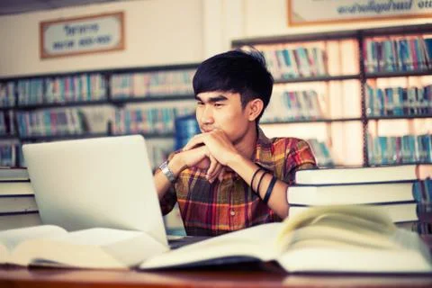 The young man is studying for knowledge in the library Stock Photos