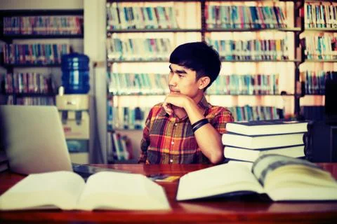 The young man is studying for knowledge in the library Stock Photos