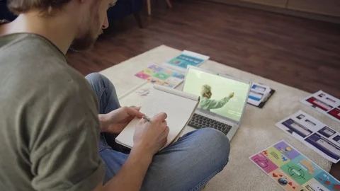 Young man studying remotely and using sanitizer at home Stock Footage 128569655
