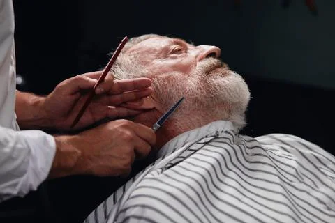 Young man styling man's beard Stock Photos