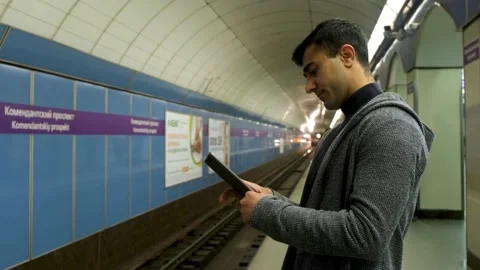 Young man at subway station platform using tablet pc computer. Media. Side view Stock Footage 139137455