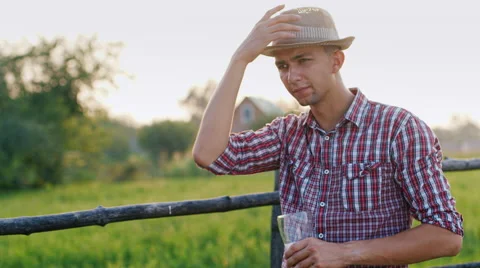 A young man suffering from the heat, drinking beer from the glass Stock Footage 65454946