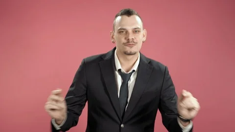 Young man in a suit dancing snapping a rhythm against pink background. Stock Footage 119648043