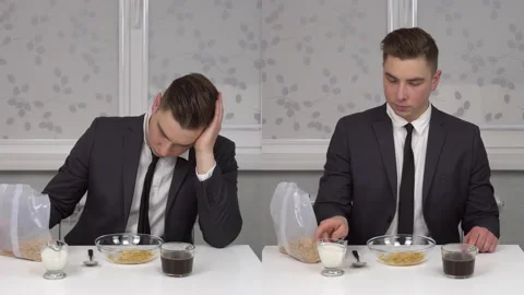 A young man in a suit eats cereal and drinks coffee, sleepy and cheerful Stock Footage 150273637