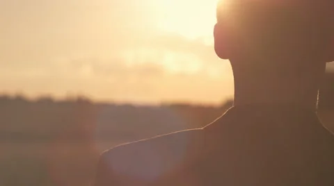 Young man in suit looking ahead at the sun during the sunrise Stock Footage 66792994