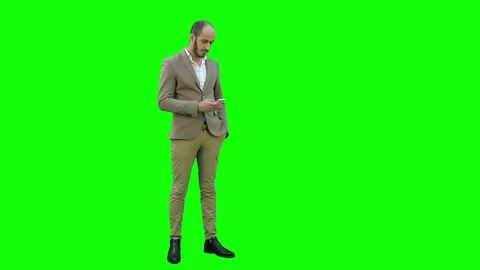 Young man in suit sending text messages on his phone on a Green Screen, Chroma Stock Footage 71204476