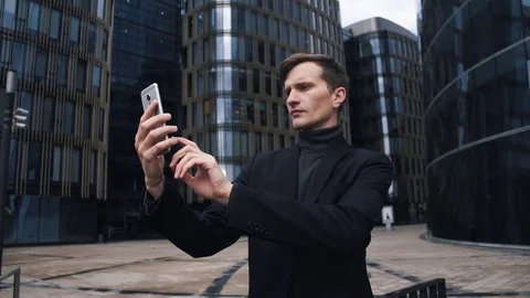 Young man in suit using smartphone. Glass business centre building at background Stock Footage 79416655
