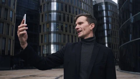 Young man in suit using smartphone. Glass business centre building at background Stock Footage 79416852