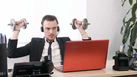 Young man in a suit is working in the office and doing an exercise for the 動画素材 83686516