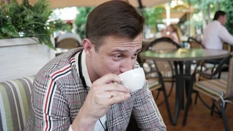 Young man in summer cafe drinks coffee keeping social distance Stock Footage 138680755