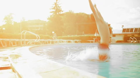 Young man in summer day is diving into outdoor swimming pool dolly Видео 64493503