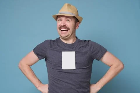 Young man in summer hat standing looking camera smiling confident on blue wal Stock Photos