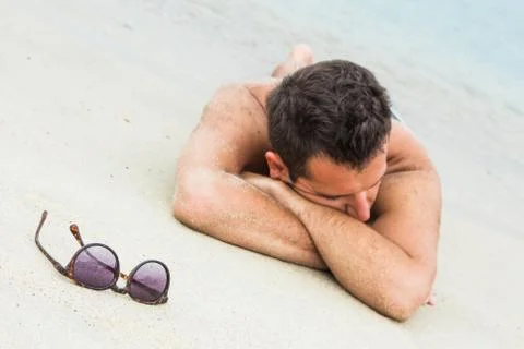 Young man sunbathing on the beach 스톡 사진