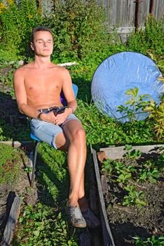 Young man sunbathing in the sun on two sides with phototriodes i Foto stock
