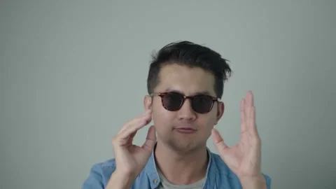 Young man sunglasses asking to be yelling on White background copy space. 動画素材 241582784
