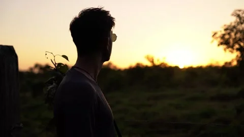 Young Man With Sunglasses Looking At Sunset in the jungle 4K 動画素材 240646707