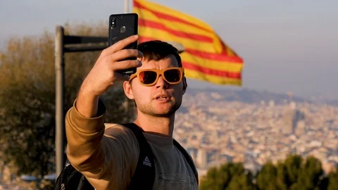 Young man in sunglasses taking selfie against the background of the flag of Stock Footage 101067836
