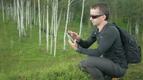 Young man in sunglasses touch Tablet PC. Against the background of beautiful Video stock 66577643