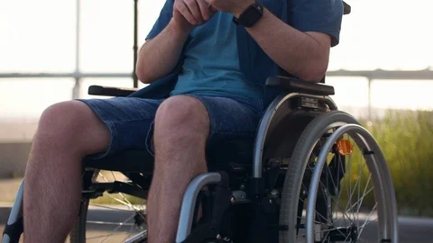 Young man in sunglasses using mobile phone, physically disabled man sits in Stock Footage 110216176