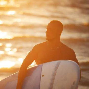 Young man at sunset with SUP Stock Photos