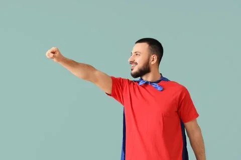 Young man with superhero cape on green background Stock Photos