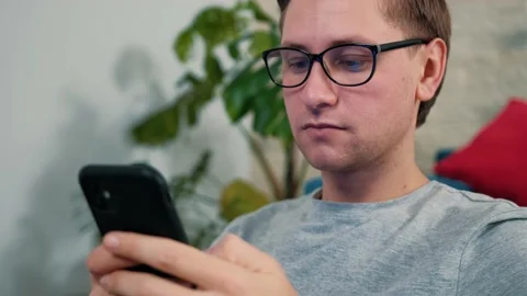 Young man surf the internet using a mobile phone, staying isolated at home. Stock Footage 146072700