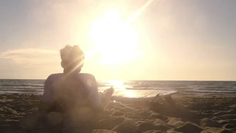 Young man surfer in wetsuit lying down with surf board on the sand at the beach 動画素材 85451650