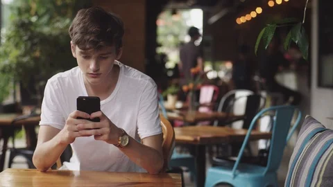 Young Man surfing internet in mobile phone, handy touch and sending text message 動画素材 112386317