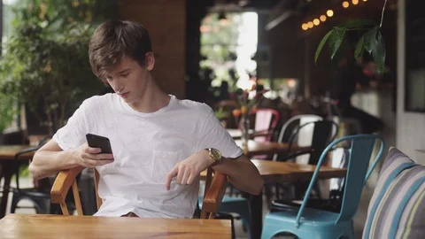 Young Man surfing internet in mobile phone, handy touch and sending text message 動画素材 112386501