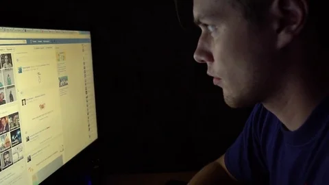 Young man surfing the net internet at night in a dark room. Chatiing in social Stock Footage 69877136