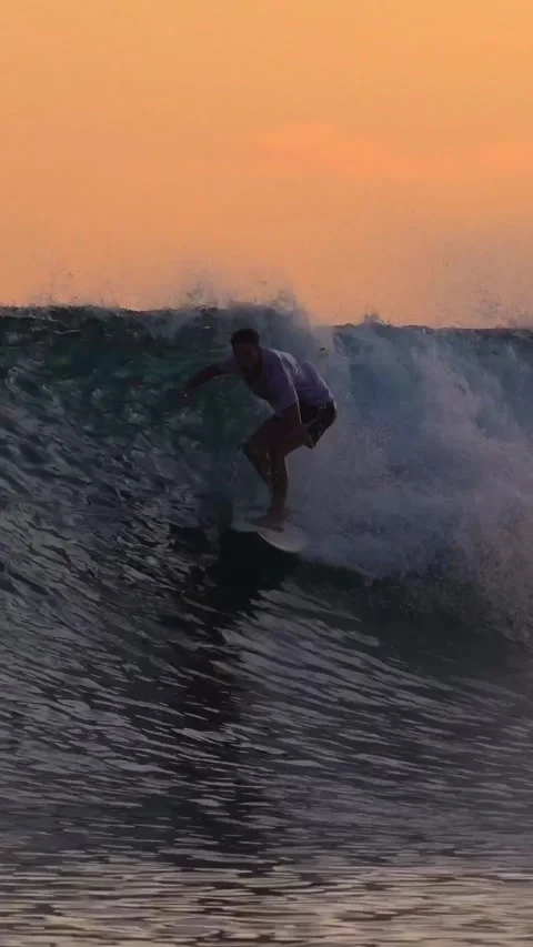 Young man surfing at sunset.Vertical video Stock Footage 295758945