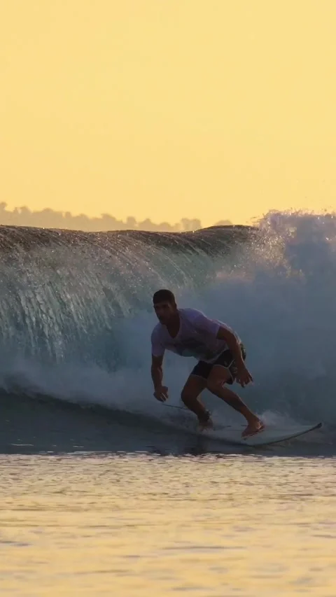 Young man surfing at sunset.Vertical video Stock Footage 295759023