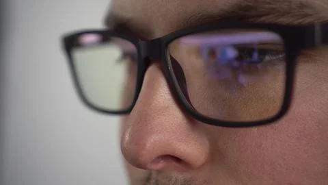 Young man surfs the internet. Reflection of a pc monitor in glasses. The IT 스톡 사진