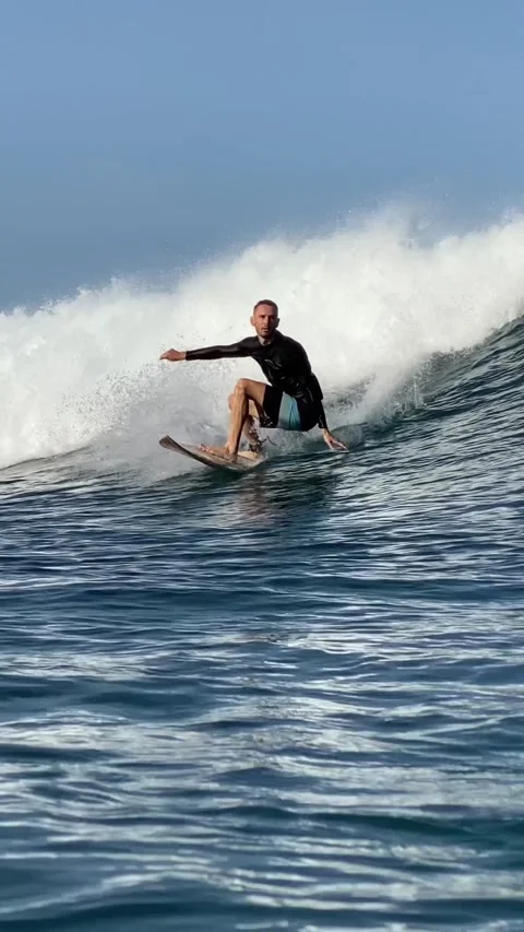 Young man surfs in the ocean. Vertical video Stock Footage 300747894