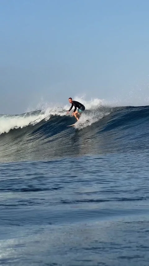 Young man surfs in the ocean. Vertical video Stock Footage 300747897