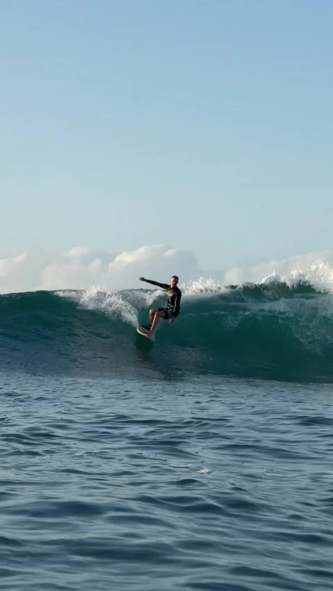 Young man surfs in the ocean. Vertical video Stock Footage 300747996