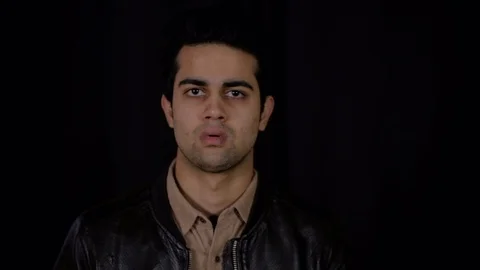 Young man is surprised at some great news from off camera as his expression chan Stock Footage 104900568