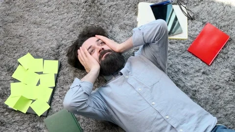 Young man surrounded by computer and documents, very tired and exhausted. Stock Footage 152257303
