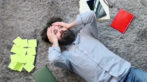Young man surrounded by computer and documents, very tired and exhausted. Stock Footage 152980161