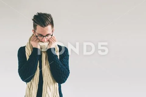 Young man in sweater feel cold over a white background. Stock Photos