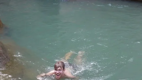 Young man swiming waterfall rocks Stock Footage 70757989