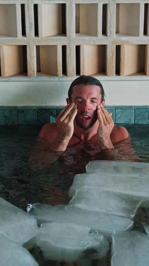 Young Man in Swimming Pool or Healthy Bath with Ice Cubes and Cold Water Stock Footage 324552691