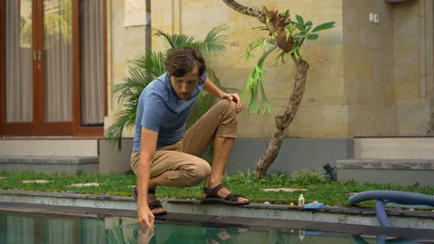Young man swimming pool serviceman checking chlorine, PH and other chemical Stock Footage 110897701